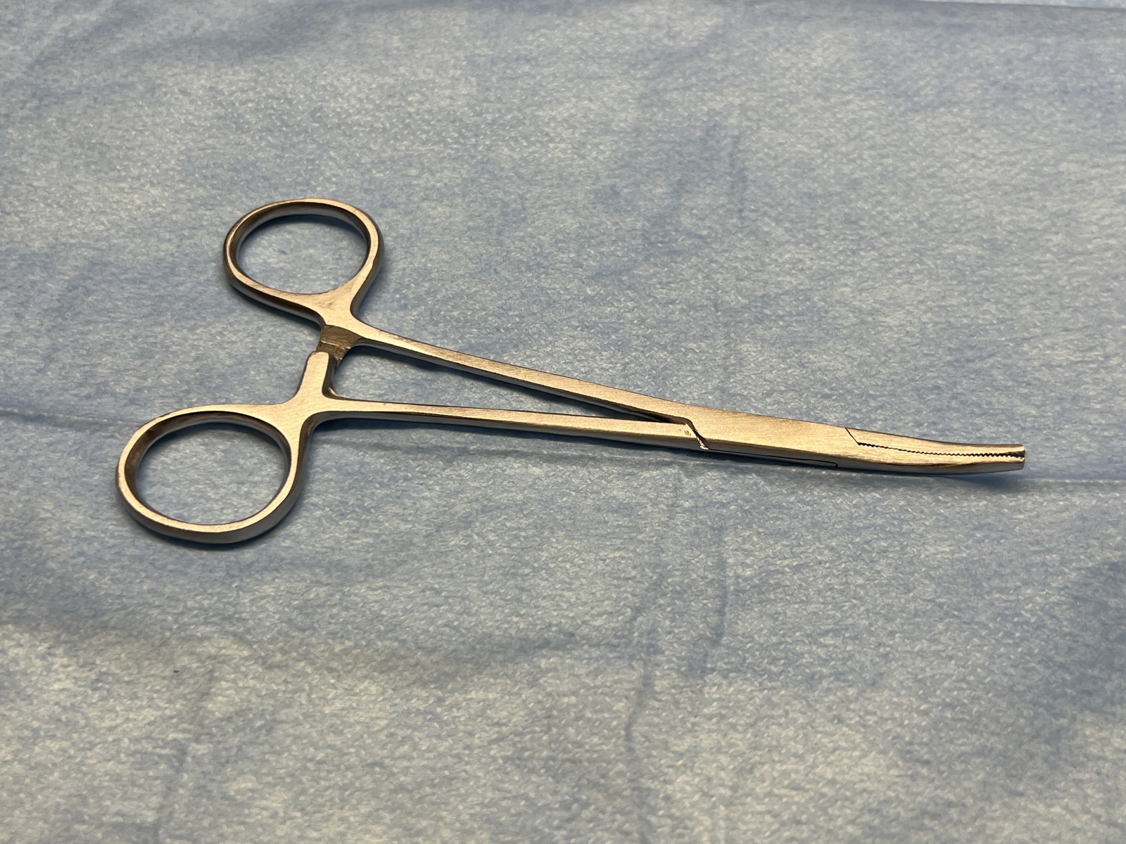 Clamp photographed from a close-up blue-background view in closed state